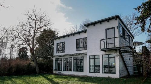 a white house with black windows at Im Scheunhornweg in Werder