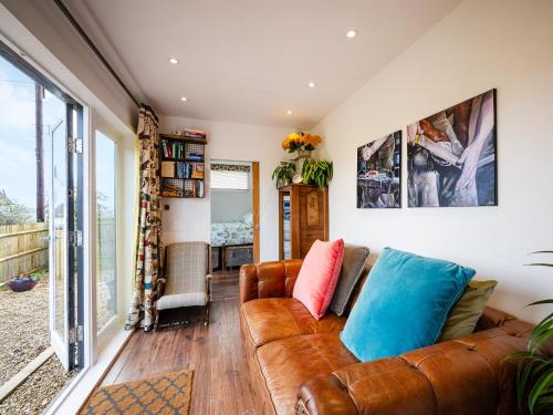a living room with a brown leather couch at Sunrise Cabin in East Ilsley