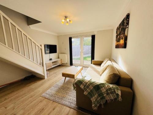 a living room with a couch and a stair case at Mezzo House- Entire property in Coventry