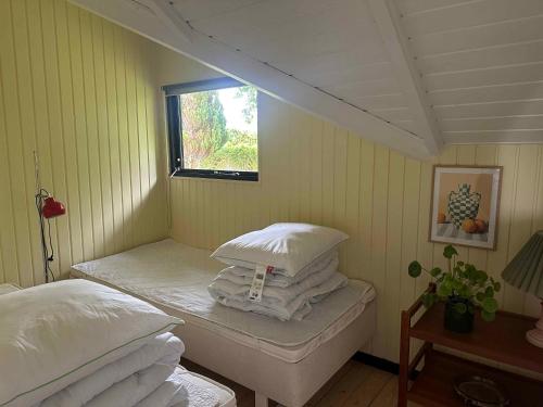 a small room with two beds and a window at Cozy Summer House With New Kitchen And Bathroom in Karrebæksminde