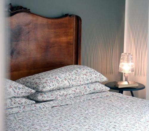 a bed with a wooden head board and two pillows at B&B Casa Trucchi in Ventimiglia