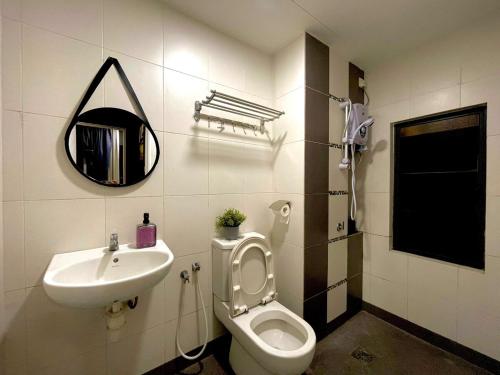 a bathroom with a sink and a toilet and a mirror at Zeva Residence Seri Kembangan 2BR in Seri Kembangan