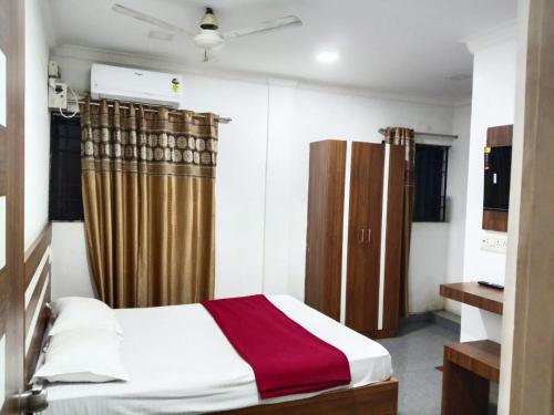 Un dormitorio con una cama con una manta roja y blanca. en Pacio Residency, en Kanchipuram