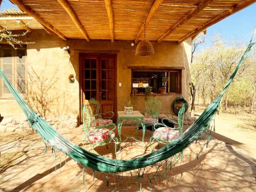 a hammock on a porch of a house at Chacra La Linda Eco San Marcos Sierras in San Marcos Sierras