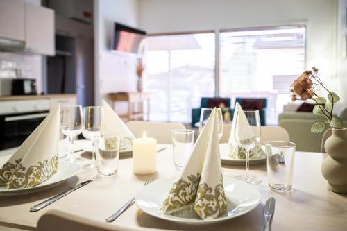 a table with plates and glasses and a candle on it at Rukariutta Apartments in Ruka