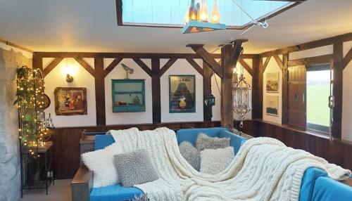 un salon avec un canapé bleu avec des oreillers dans l'établissement The Old Barn ZIMOWY HIT Jacuzzi Piecyk Butikowy Dom 2 Noce minimum, à Płóczki Górne