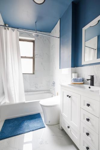 a bathroom with a white toilet and a blue wall at Ultimate Urban living at Centrally Located Apartments in New York