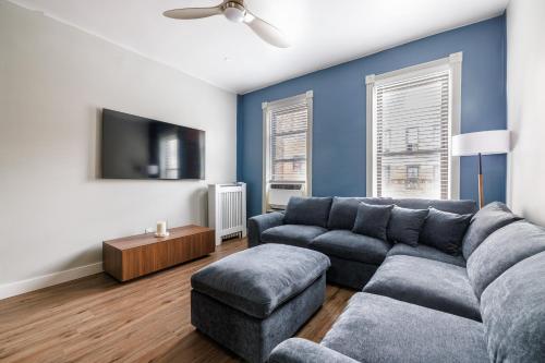 a living room with a couch and a tv at Ultimate Urban living at Centrally Located Apartments in New York