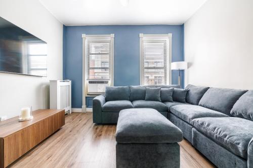 a living room with a gray couch and a table at Ultimate Urban living at Centrally Located Apartments in New York