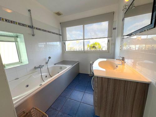 a bathroom with a tub and a sink and a bath tub at Villa du Rocher in Sibiril