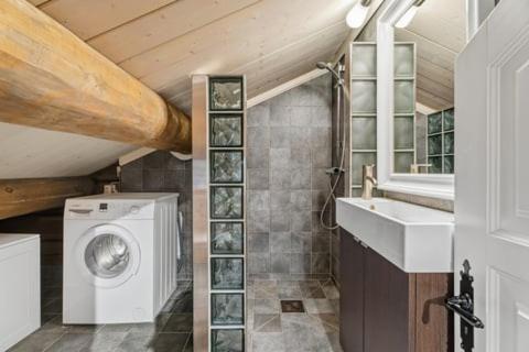 une salle de bain avec une machine à laver et un lavabo dans l'établissement Luxurious 4 bedroom Mountain Cabin with Gaustatoppen View, à Gaustablikk