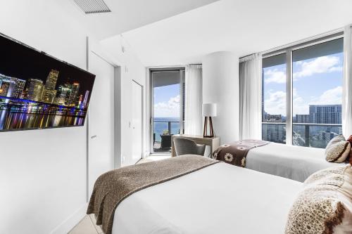 ein Hotelzimmer mit zwei Betten und einem Flachbildfernseher in der Unterkunft Lyfe Resort Access 5 Stars at Hallandale Beach in Hollywood