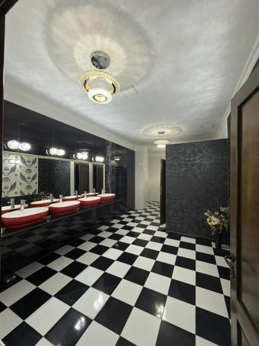 a bathroom with a checkered floor and red benches at Hotel Abi in Baile Felix