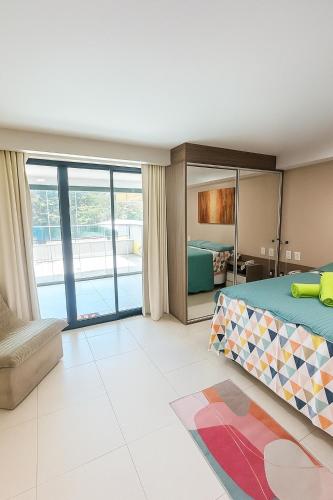a bedroom with a bed and a balcony at Tabatinga Flat - Pé na Areia! Beira Mar! in Conde