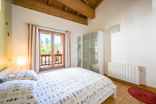 ein Schlafzimmer mit großem Bett und Fenster in der Unterkunft Le Grenier - Chalet DDA La Combe in La Combe