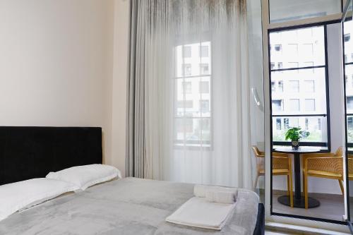 a bedroom with a bed and a table and a window at Luxe Living Studio in Tirana