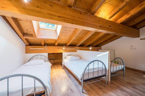 La CombeにあるLa Maison - Chalet DDA La Combeの木製天井のドミトリールームのベッド2台分です。