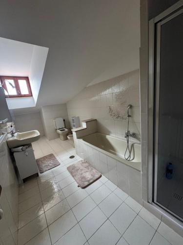 a white bathroom with a tub and a toilet at A Casa di Micol in Poggio Mirteto