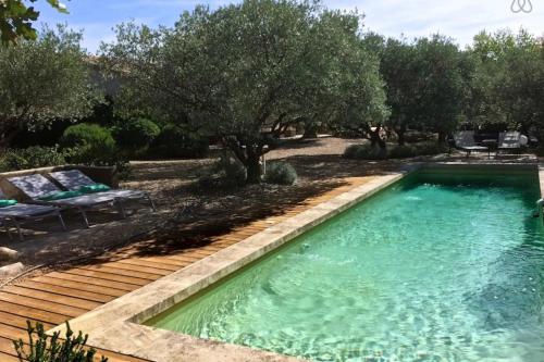 a swimming pool in a yard with a wooden deck at La Matina Family Haven with Olive Garden Oasis in Lauris