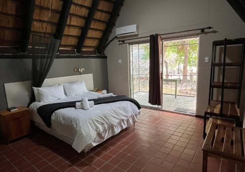 ルンドゥにあるNgandu Hotel - Runduのベッドと大きな窓のある寝室