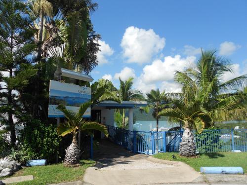 a building with palm trees in front of the ocean at Coral Point Lodge in Shute Harbour