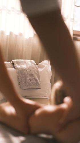 a woman is sitting on a bed with a towel at Hotel GRACE LA MARGNA ST MORITZ in St. Moritz