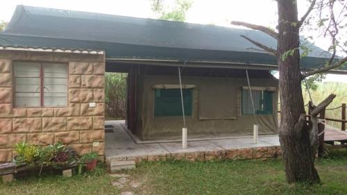 a small house with a black roof at Proudly Okavango self-catering Burnside in Shakawe