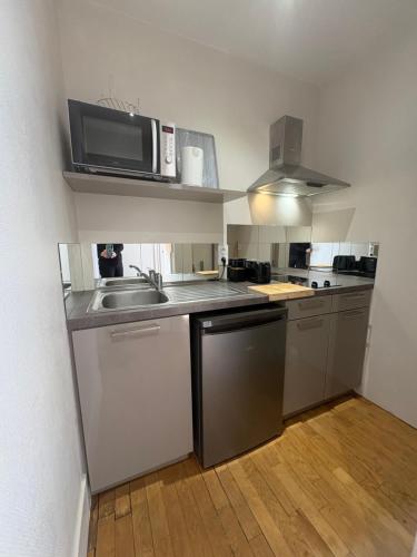 a kitchen with a sink and a microwave at Suite studio Darcy in Dijon