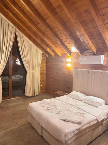 een slaapkamer met een groot wit bed en houten plafonds bij Real Love Villas in Sakarya