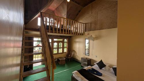 a room with a staircase and a bed in a room at ATC Samalbong Paharer Bari in Kalimpong
