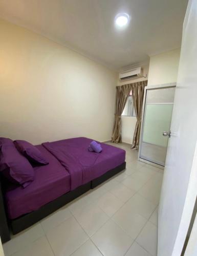 a bedroom with a purple bed in a room at Tiara Homestay Desaru - Nature view in Bandar Penawar