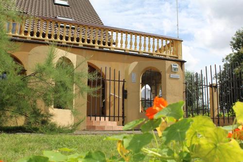 a house with a balcony and a fence at Arkady in Słupsk
