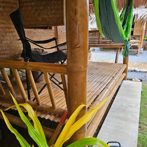 a wooden porch with chairs and an umbrella at Long beach simple House in Ko Lanta