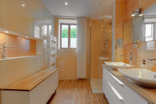 a bathroom with two sinks and a shower at Les Aubépines en Beaujolais in Salles-Arbuissonnas