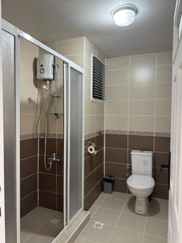 a small bathroom with a toilet and a shower at Villa Martin Mersin in Mezitli