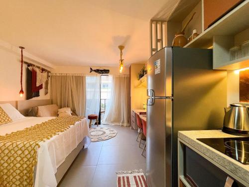 a kitchen with a refrigerator and a bed in a room at Beach Haus by Hosppedar in João Pessoa
