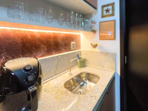 a kitchen sink with a camera on a counter at Beach Haus by Hosppedar in João Pessoa