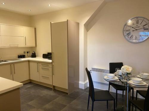 a kitchen with a table and a clock on the wall at The Waterfront Suite in Southport