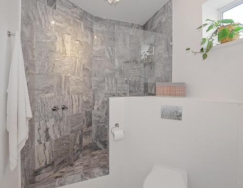 Beachfront, Sea Views, WiFi, Fireplace, 1-Min Walk في Cape Town: حمام بجدار حجري