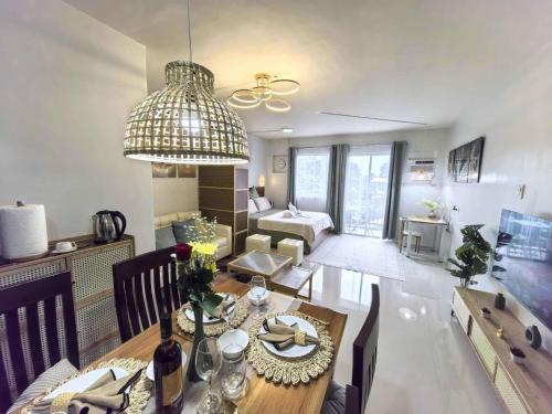 comedor y sala de estar con mesa de comedor en Cozy Studio with Balcony in Palawan Smart Lock, Near Airport, Netflix, Free Wifi, en Bancaobancao