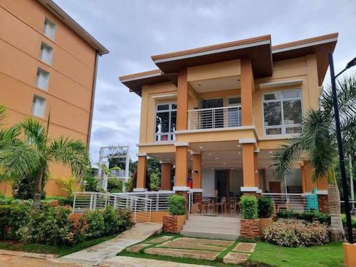 una casa con palmeras delante en Cozy Studio with Balcony in Palawan Smart Lock, Near Airport, Netflix, Free Wifi, en Bancaobancao