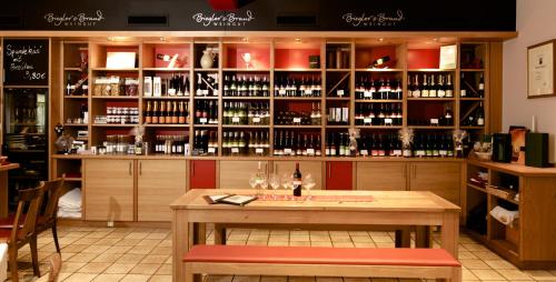 a bar with a table and a shelf of wine bottles at Weinhotel Kaisergarten in Alzey