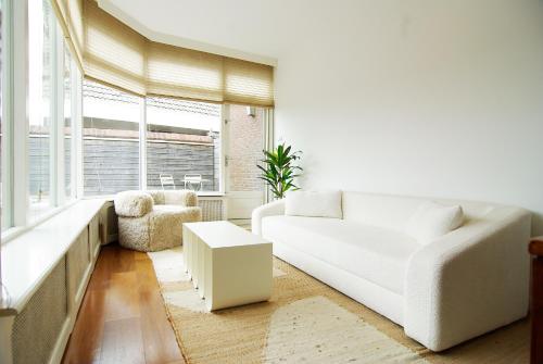 a living room with a white couch and a table at spacious new appartment in Lisse