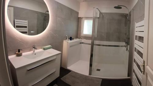 a bathroom with a sink and a shower with a mirror at Chez Caroline Chambre d'Hôtes in Plouër-sur-Rance