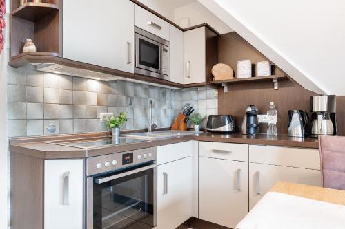 シャルボイツにあるSchmiedestraße 3 Wohnung 7の白いキャビネットとシンクのあるキッチン