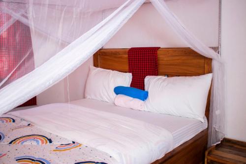 a bedroom with a canopy bed with white pillows at Meru Villa Arusha in Olmotoni