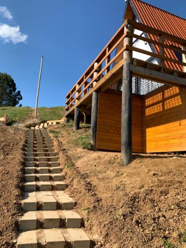 a house with a stone path leading to a building at Chales alto do morro 1, conforto e vista privilegiada in Rancho Queimado