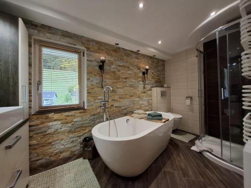 Un baño grande con bañera y ducha. en Ferienhaus im Pochwerksgrund in Suhl Goldlauter im Thüringer Wald, en Suhl