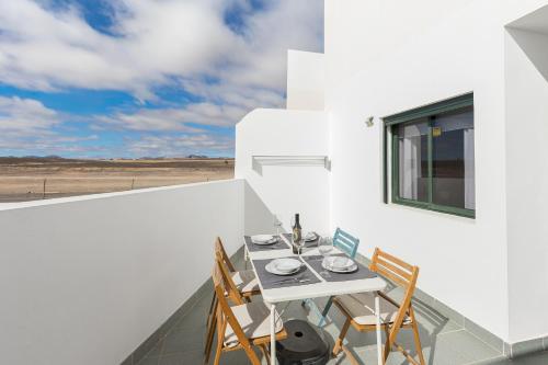 a dining room with a table and chairs on a balcony at Home2Book Sunny Terrace Getaway Puerto Lajas in Puerto de las Lajas