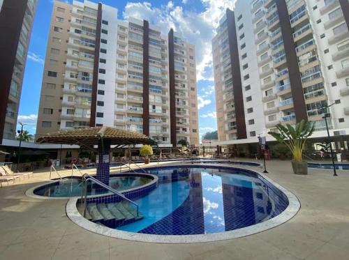 a large swimming pool in front of tall buildings at Apartamento Familiar - Casa Da Madeira in Caldas Novas